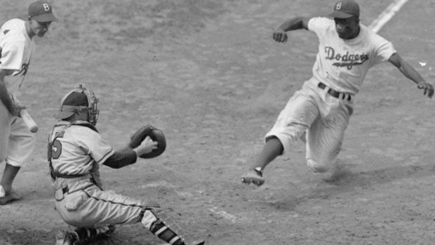 Jackie Robinson in action with his trademark home-base steal in 1948.