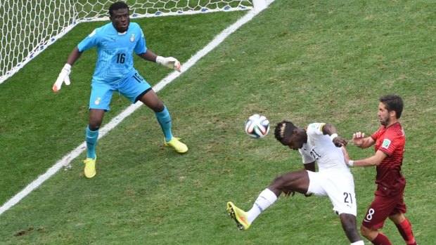 Ghana's defender John Boye (centre) hits the ball to score an own goal as Portugal's midfielder Joao Moutinho (right) watches on. Boye was filmed kissing the $US3 million cash sent over before the game by Ghana's President.