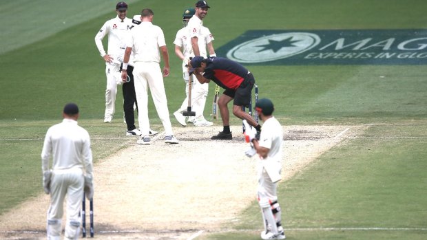 Wake up: A groundsman takes a sledgehammer to the MCG pitch during the Boxing Day Test.