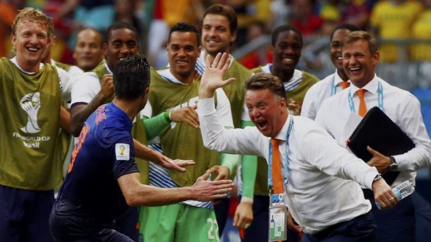Robin van Persie rushes to celebrate with the Dutch bench after his stunning header.