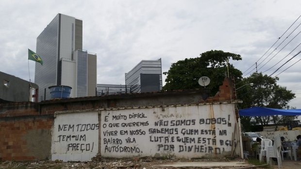 Houses at Vila Autodromo before they were demolished, with the Olympics' main press centre in the background, Barra da Tijuca.