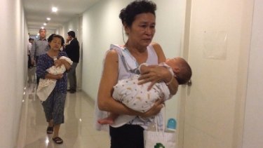Officials conduct a raid on a surrogacy agency in Thailand in 2014.