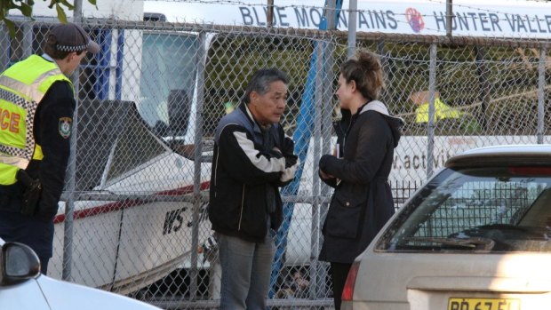 Police interview Masaaki Imaeda at the scene of the fire in Alexandria last July.