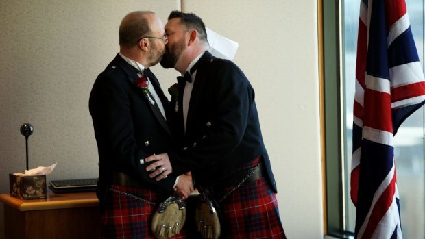 Mr Stevenson and Mr Fraser embrace after exchanging rings at their wedding at the British consulate in Sydney on Friday.