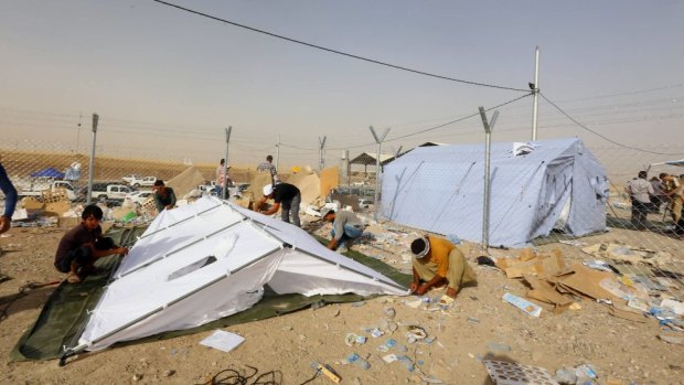 Iraqi refugees from Mosul set up a tent at Khazir refugee camp.