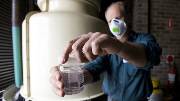 An environmental health officer tests a water cooler tower.