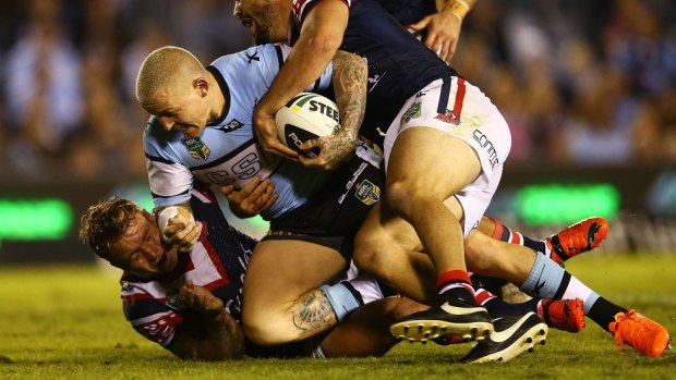 Cronulla five-eighth Todd Carney is brought to ground by the Roosters.