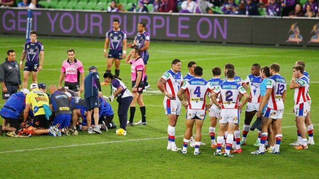 Ill-fated match: Alex McKinnon receives treatment on the field after being injured in a dangerous throw tackle against Melbourne last year.