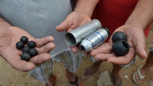 Residents hold ammunition they say was used by police at Vila Autodromo.