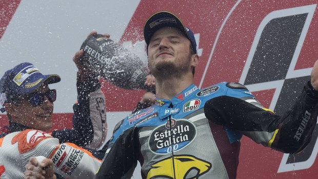 Shock victory: Jack Miller is sprayed in champagne by Marc Marquez after winning his maiden MotoGp race.