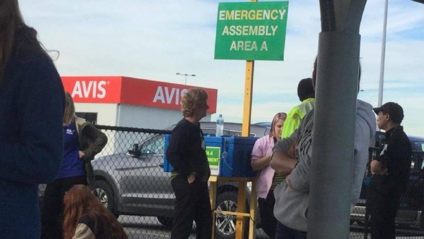 Passengers wait at the emergency evacuation area after an alarm went off at Perth Airport on Thursday morning.