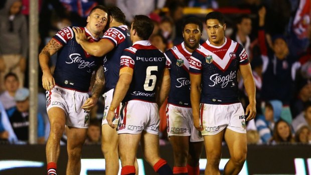 The Roosters congratulate Shaun Kenny-Dowall after scoring against Cronulla.
