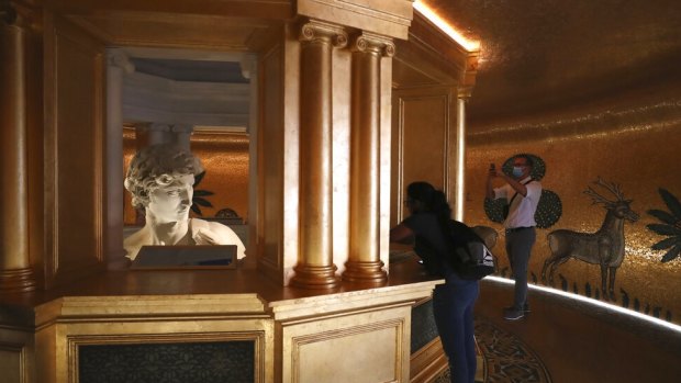 Visitors take photos of the 3D re-production of Michelangelo's David in Dubai.