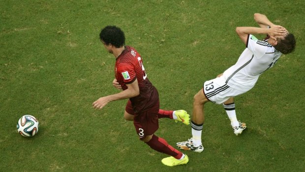 Germany's Thomas Mueller reacts after being hit by Portugal's Pepe.