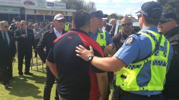 Jeffery Humphries is escorted from the ground by police after punching an umpire following the SWFL reserves grand final.