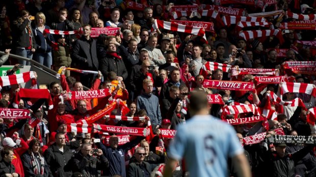 Liverpool supporters hold their scarves before the minute's silence for the victims.