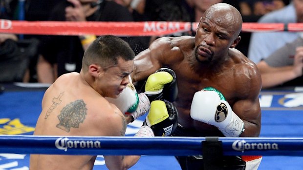 First match ... Roger Mayweather lands a right on Marcos Maidana during their first bout in May.