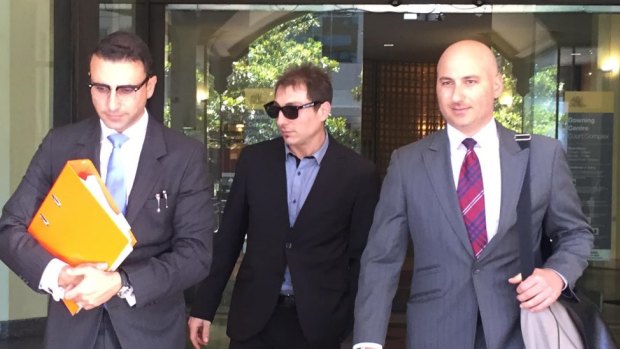 Giovanni​ Mancuso (centre) leaves court after being sentenced.