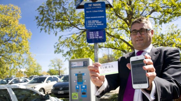 Justice and Community Services executive director Brett Phillips demonstrates the new parking metre phone app.
