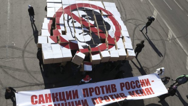 Speaking out: Protesters hold up boxes to make a portrait of  Barack Obama during a flashmob event by students in Moscow . The slogan on the boxes reads, "Sanction against Russia are sanctions against me!" 