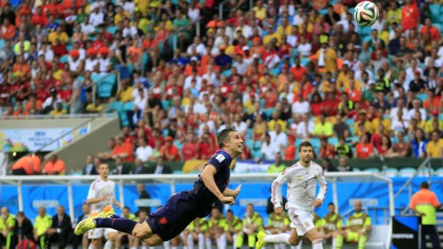 Diving force: Robin van Persie heads home in the Netherlands' demolition of Spain.