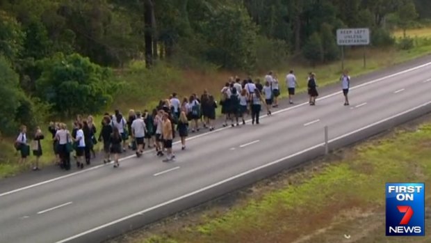 Students walk to safety as their bus burns in the northbound lane of the Bruce Highway near Sippy Downs, north of Brisbane.