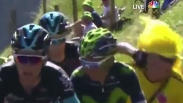 Chris Froome lashes out at an overzealous fan who was in his way.