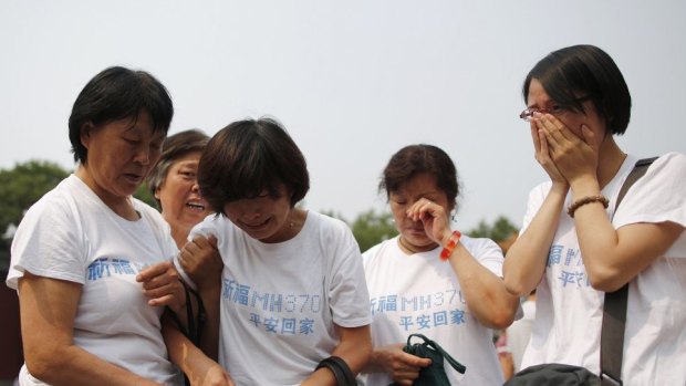 Relatives of passengers aboard the missing jet gather at a Beijing temple in June.