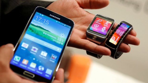 The new Samsung Galaxy S5 smartphone, left, with the Gear 2 smartwatch, centre, and Gear Fit fitness band. Samsung has added biometrics to its new flagship device.
