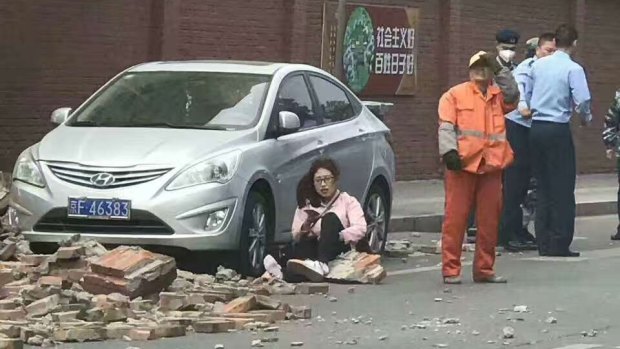 Winds swept Beijing on Friday, blowing down trees and walls and killing at least one person.