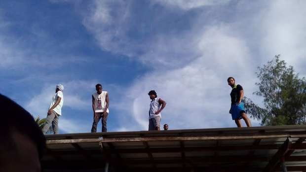 Refugees scaled the roof of a compound inside the decommissioned detention centre as police entered.