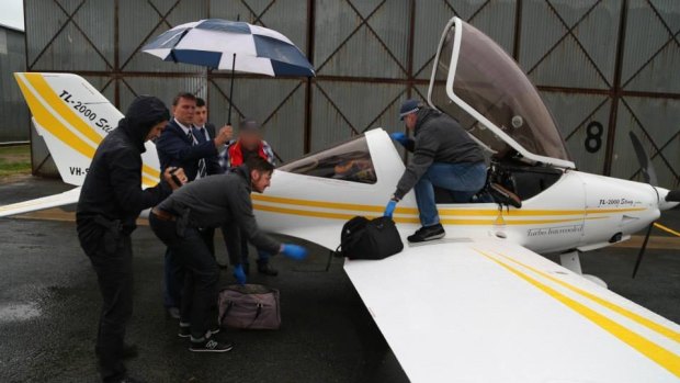 Police unload bags from the plane at Deniliquin airport.