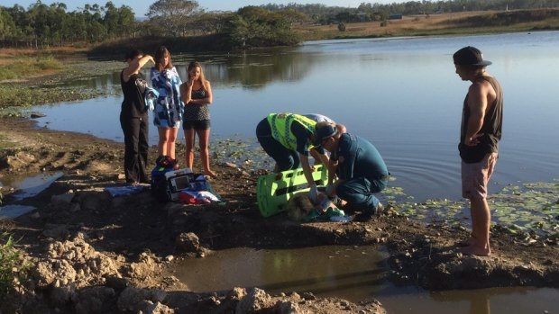 Paramedics treat a crash victim south of Airlie Beach.