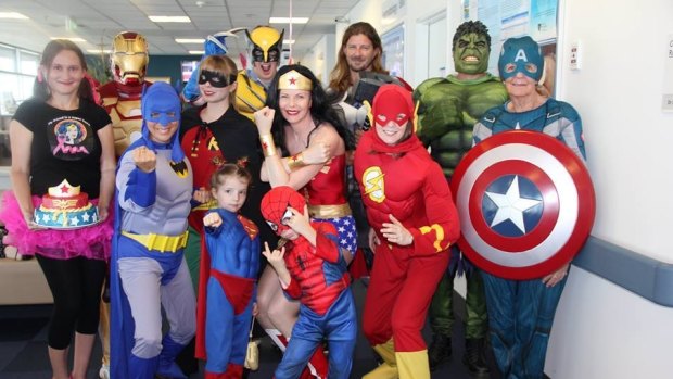 Her twin daughters, dressed as Spider-Man and Superman (in front), accompanied her for the last day of chemotherapy treatment.