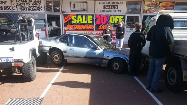 The Honda sedan somehow ended up horizontally between two parked cars in Osborne Park