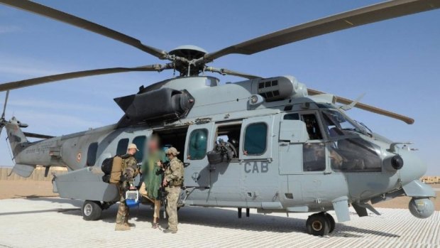 Two soldiers of the French special forces help  Dutch national Sjaak Rijke, centre, as he gets off a Caracal helicopter after his rescue at an airbase in Mali.