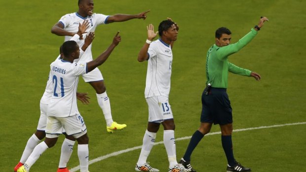 Honduras players protest the disputed goal.