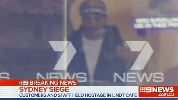 Man Haron Monis seen through the glass of the Lindt cafe.