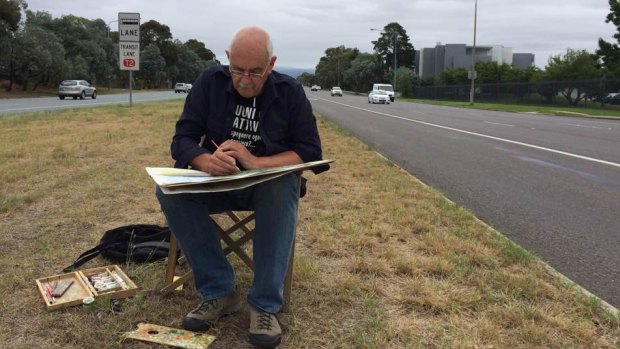 Canberra artist Christopher Oates works on a painting in the middle of six-lane Adelaide Avenue.