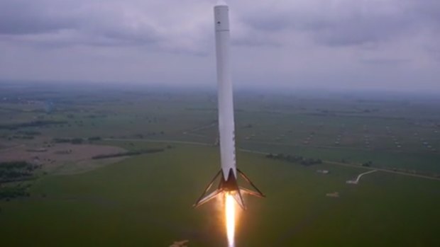 A screen grab from a video a drone shot showing a prototype reusable rocket launch and land itself.

