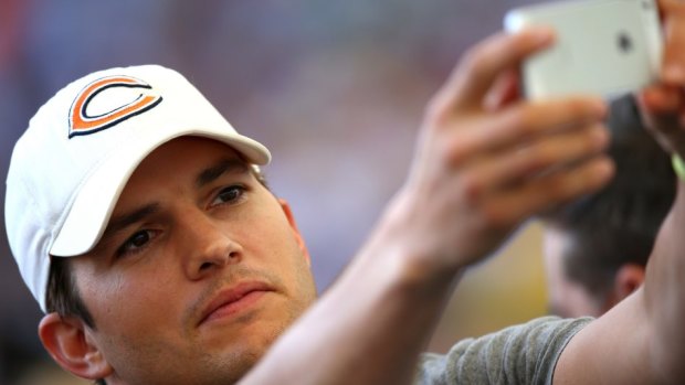 Actor Ashton Kutcher takes a selfie before the match.