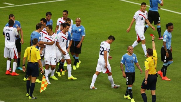 Maximilliano Pereira of Uruguay becomes the first player to be sent off at the World Cup in Brazil.