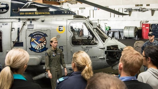 Lt. j.g. Jennifer Sing, a pilot from the "Saberhawks" of Helicopter Maritime Strike Squadron 77, speaks with Australian visitors during a tour of the Nimitz-class aircraft carrier.