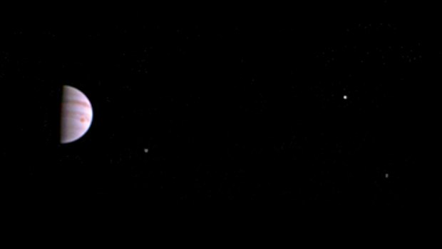 Juno's first transmitted picture shows Jupiter with three of its four largest moons.