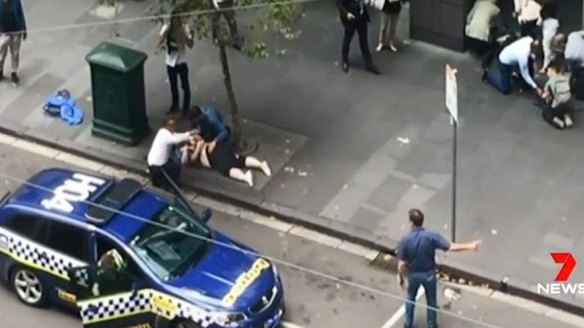 An image of Henry Dow and the taxi driver known as 'Lou' caring for a victim of the Bourke Street attack on Friday.