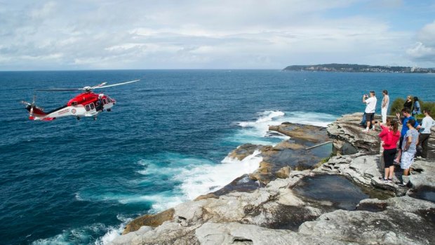 A rescue helicopter attends the scene where a rock fisherman died on the northern beaches. 