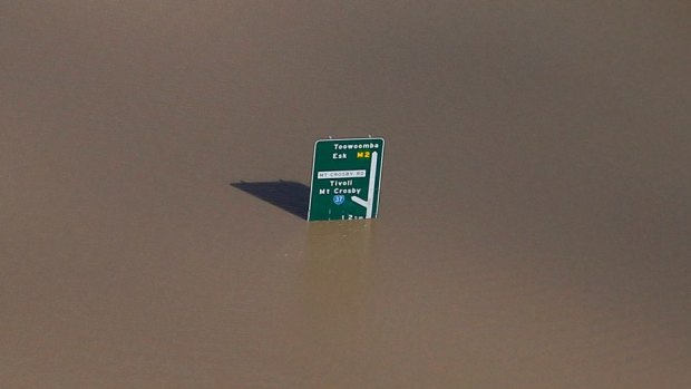 A road sign sticks up above a flooded motoway..