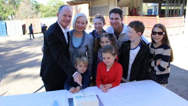 Premier Campbell Newman cuts cake with children and representatives of Hear and Say.