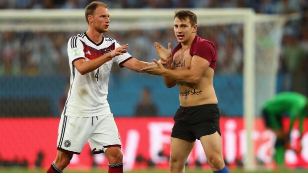 Prankster Vitaly Zdorovetskiy invades the pitch to confront German player Benedikt Hoewedes.
