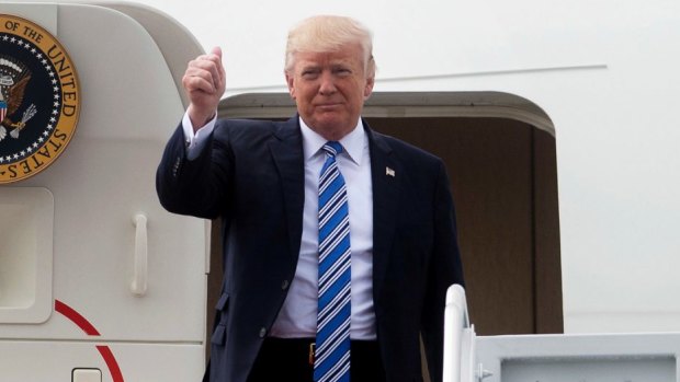 Thumbs up: Business as usual for US President Donald Trump as he disembarks Air Force One on Saturday.